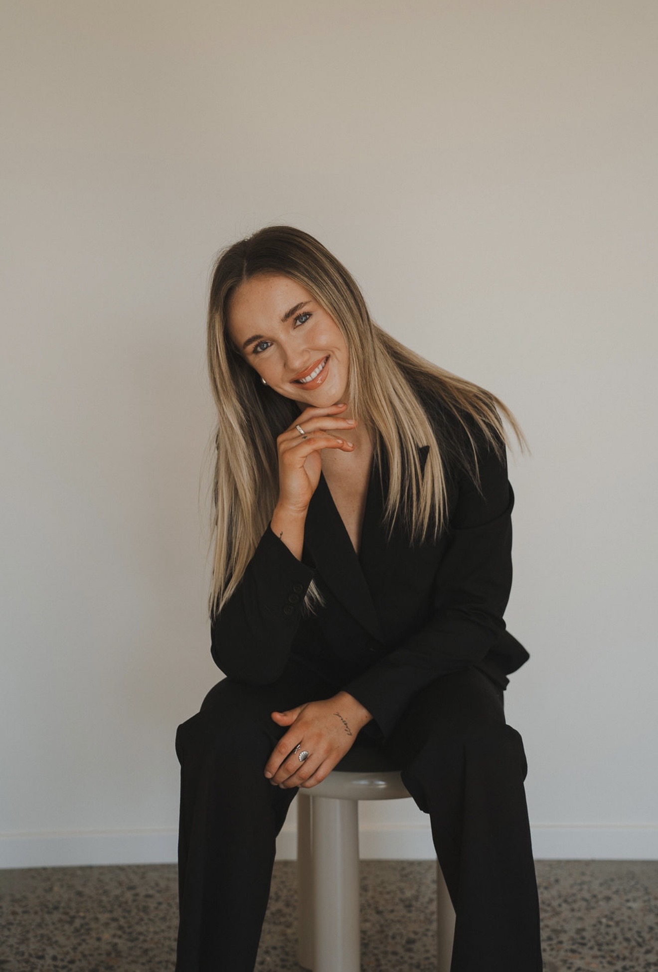 Founder of Social Rise Collective seated in a black suit